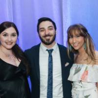 Three guests with arms around each other.